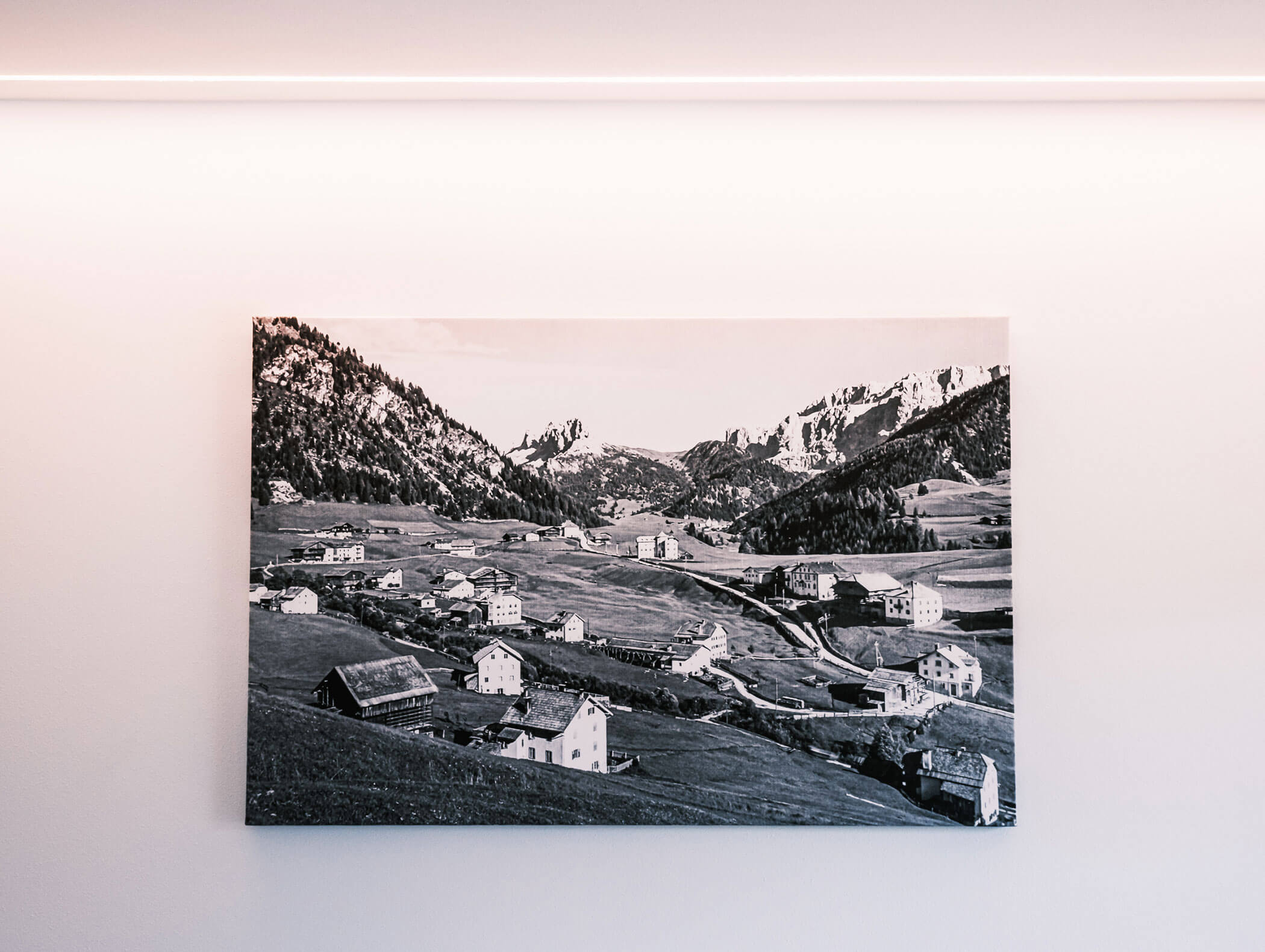 Black and white photo of a mountain village displayed on a plain white wall. - Hotel Kristiania