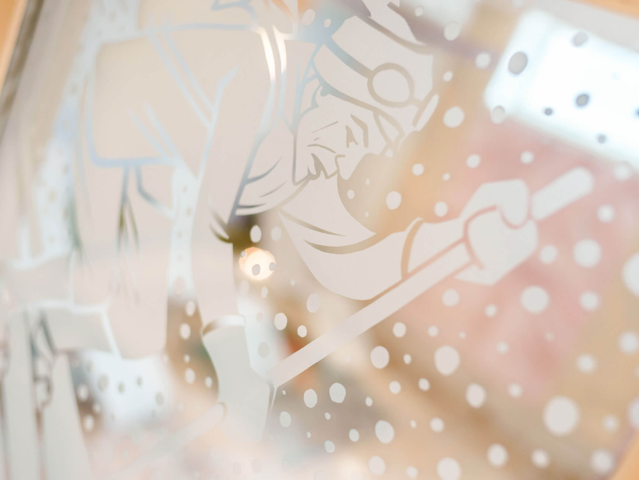 Etched glass art of a skier in goggles and winter gear, surrounded by falling snow. - Hotel Kristiania