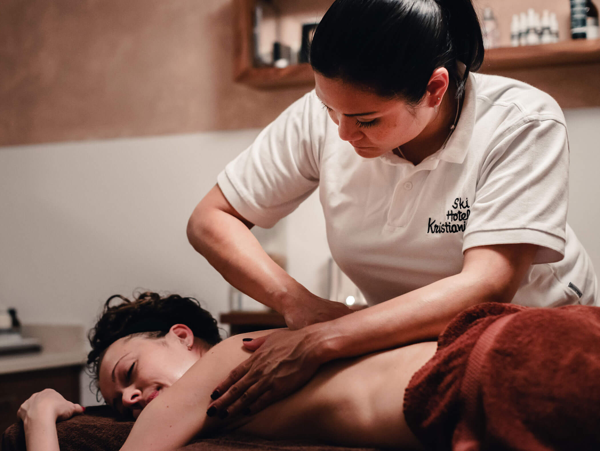 Eine Frau genießt eine entspannende Rückenmassage von einem Therapeuten in einer gemütlichen Spa-Atmosphäre. - Hotel Kristiania