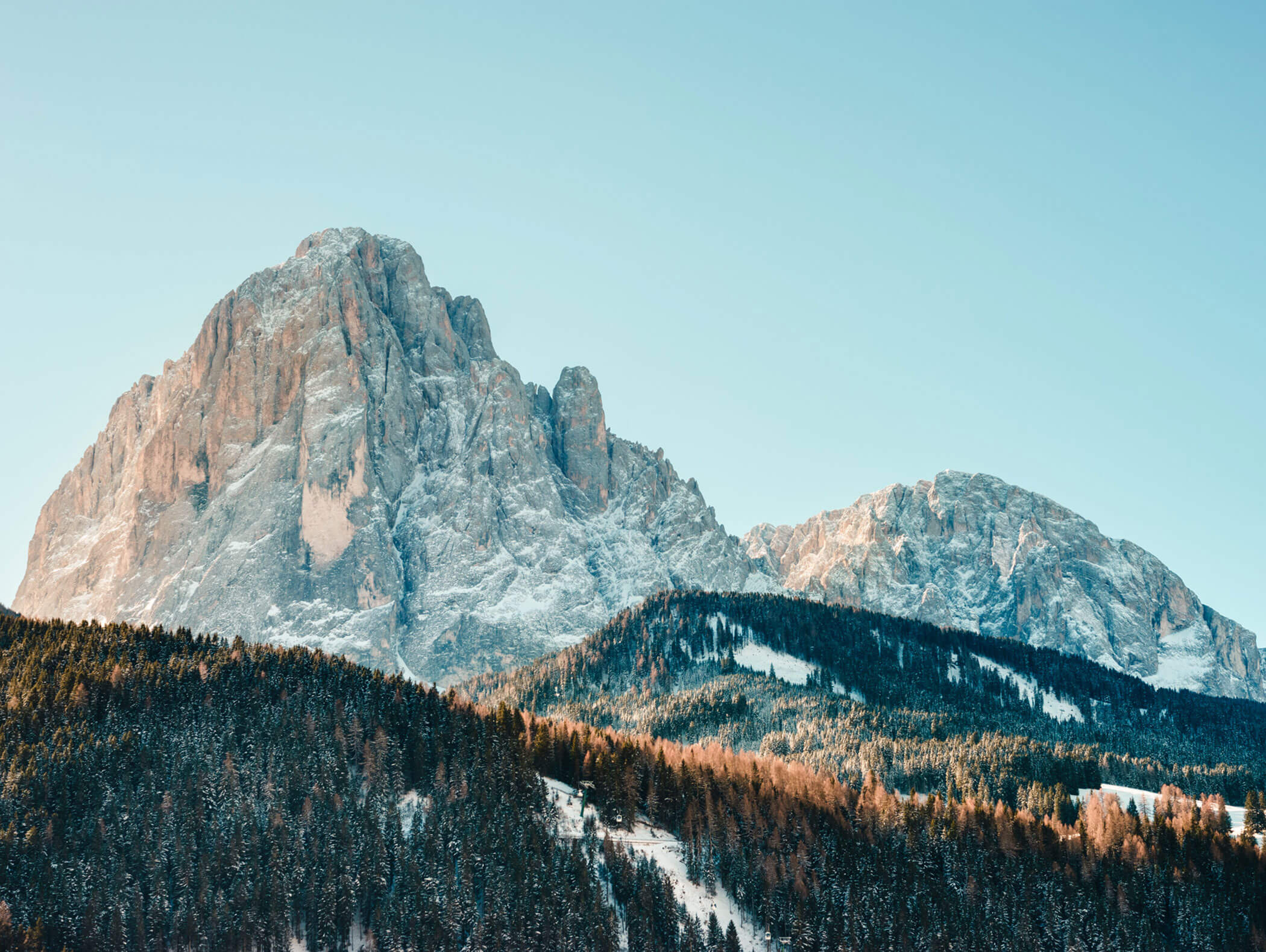 Cime montuose innevate e colline boscose sotto un cielo limpido e azzurro. - Hotel Kristiania