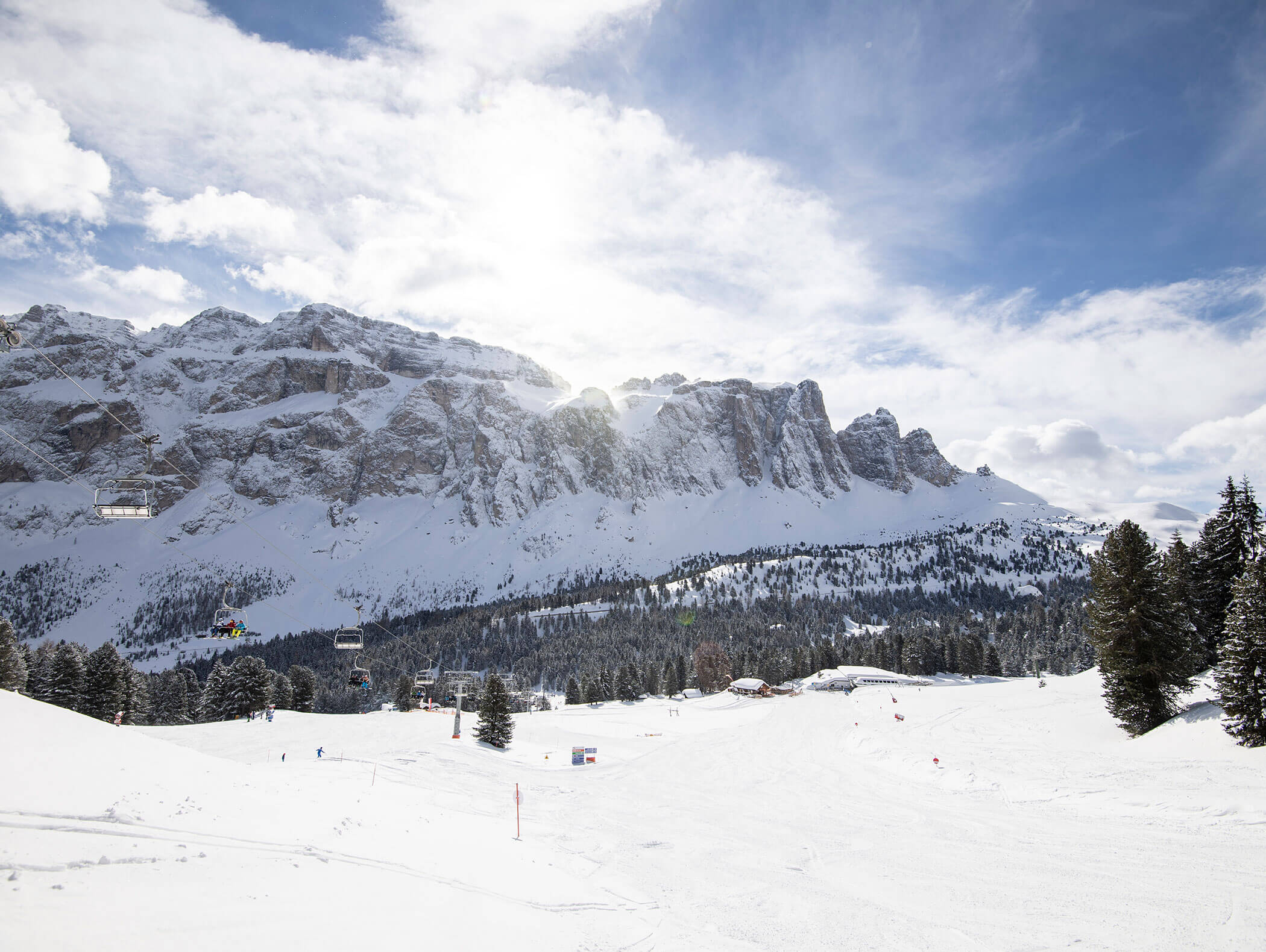 Paesaggio montano innevato con alberi sempreverdi e impianti di risalita sotto un cielo parzialmente nuvoloso. - Hotel Kristiania